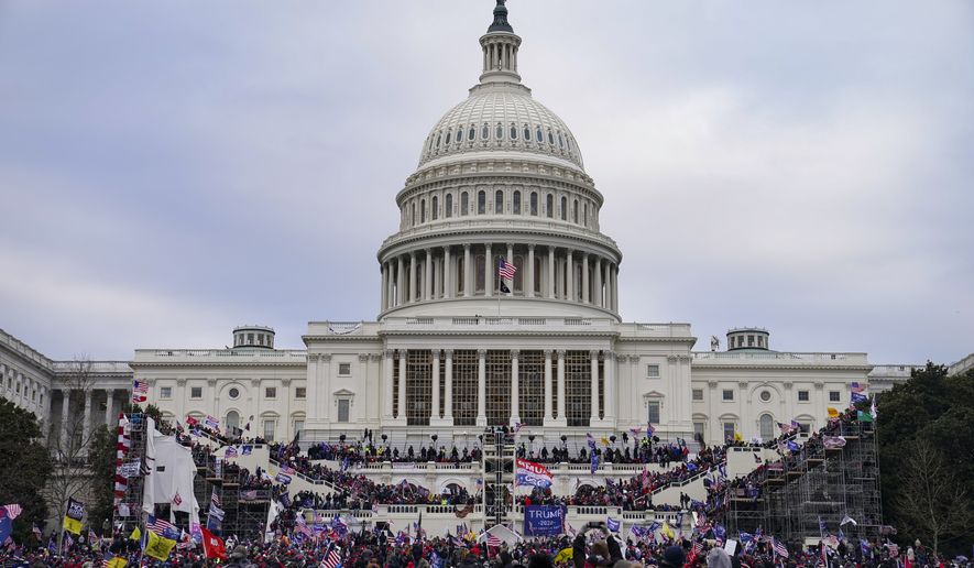 This photo from Wednesday Jan. 6, 2021, shows Trump supporters swarming the Capitol, as Congress prepares to affirm President-elect Joe Biden's victory. A little used Civil War-era statute that outlaws waging war against the United States is getting a fresh look after the attacks on the Capitol. (AP Photo/John Minchillo) **FILE**