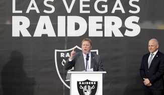 FILE - Las Vegas Raiders owner Mark Davis, center, speaks during a news conference, officially renaming the Oakland Raiders to the Las Vegas Raiders, in front of Allegiant Stadium in Las Vegas in this, Jan. 22, 2020, file photo. Raiders president Marc Badain listens at right. Mark Davis is expanding his sports empire in Las Vegas, buying the Aces from MGM Resorts International. The Raiders owner purchased the WNBA team Thursday, Jan. 14, 2021, pending approval from the league&#39;s board of governors.(Steve Marcus/Las Vegas Sun via AP, File)