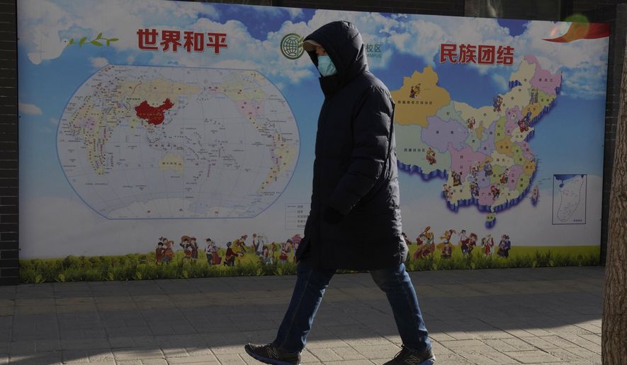 A man walks past a poster with the slogans &amp;quot;World Peace&amp;quot; and &amp;quot;Ethnic Unity&amp;quot; in Beijing, China Monday, Jan. 11, 2021. A Chinese official on Monday denied Beijing has imposed coercive birth control measures among Muslim minority women, following an outcry over a tweet by the Chinese Embassy in Washington claiming that government polices had freed women of the Uighur ethnic group from being &amp;quot;baby-making machines.&amp;quot; (AP Photo/Ng Han Guan)
