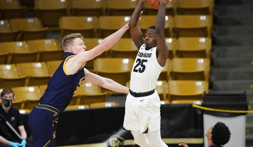 Colorado guard McKinley Wright IV, center, pulls in a rebound between California guards Ryan Betley, left, and Jarred Hyder in the first half of an NCAA college basketball game Thursday, Jan. 14, 2021, in Boulder, Colo. (AP Photo/David Zalubowski)