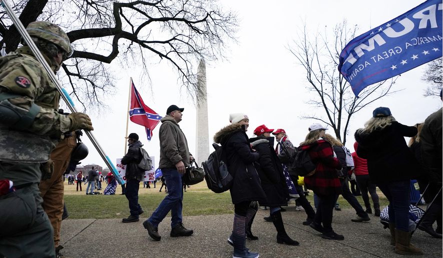 In this Jan. 6, 2021, file photo, Trump supporters gather on the Washington Monument grounds in advance of a rally in Washington. Both within and outside the walls of the Capitol, banners and symbols of white supremacy and anti-government extremism were displayed as an insurrectionist mob swarmed the U.S. Capitol. (AP Photo/Julio Cortez, File)
