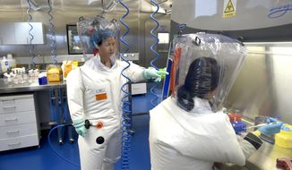 In this Feb. 23, 2017, file photo, Shi Zhengli works with other researchers in a lab at the Wuhan Institute of Virology in Wuhan in central China&#39;s Hubei province. (Chinatopix via AP, File)  ** FILE **