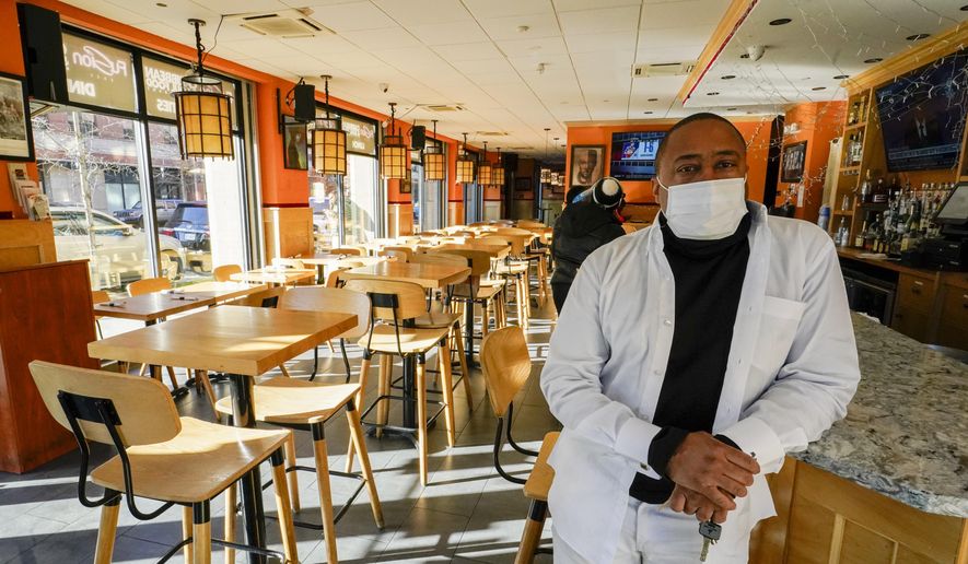 In this file photo, Andrew Walcott, owners of Fusion East Caribbean &amp; Soul Food restaurant, poses for a photo at the restaurant in East New York neighborhood of the Brooklyn borough of New York, Thursday, Jan. 7, 2021. Walcott had to furlough four employees at his restaurant just before Christmas, after New York state stopped allowing indoor dining. (AP Photo/Mary Altaffer) **FILE**