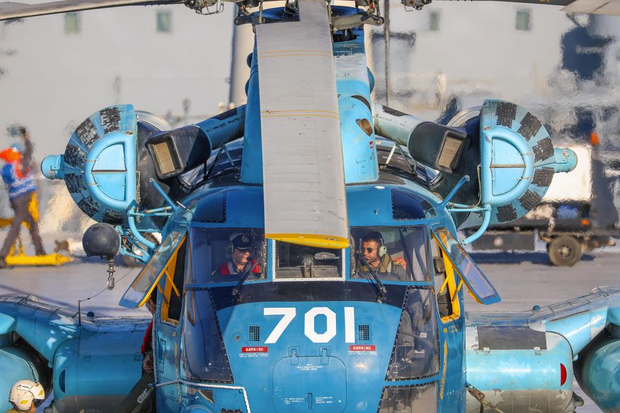 This image released Thursday, Jan. 14, 2021, by the Iranian Army shows a helicopter on an Iranian-made Makran logistics vessel during a naval drill. Iran fired cruise missiles Thursday as part of the drill in the Gulf of Oman, state media reported, amid heightened tensions with the U.S. (Iranian Army via AP)