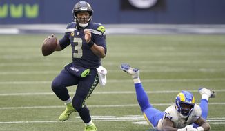 Seattle Seahawks quarterback Russell Wilson (3) scrambles away from Los Angeles Rams outside linebacker Leonard Floyd during the second half of an NFL wild-card playoff football game, Saturday, Jan. 9, 2021, in Seattle. (AP Photo/Ted S. Warren)