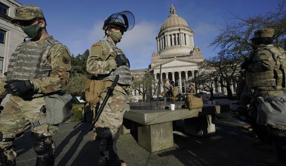 Members of the Washington National Guard stand at a sundial near the Legislative Building, Sunday, Jan. 10, 2021, at the Capitol in Olympia, Wash. Governors in some states have called out the National Guard, declared states of emergency and closed their capitols over concerns about potentially violent protests. Though details remain murky, demonstrations are expected at state capitols beginning Sunday and leading up to President-elect Joe Biden&#39;s inauguration on Wednesday. (AP Photo/Ted S. Warren)