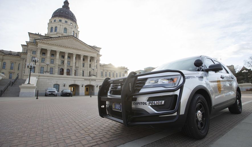 A Capitol Police vehicle with the Kansas Highway Patrol sits parked outside the Kansas Statehouse Thursday afternoon, Jan. 14, 2021, in Topeka, Kan. Governors in some states have called out the National Guard, declared states of emergency and closed their capitols over concerns about potentially violent protests. Though details remain murky, demonstrations are expected at state capitols beginning Sunday and leading up to President-elect Joe Biden's inauguration on Wednesday. (Evert Nelson/The Topeka Capital-Journal via AP)