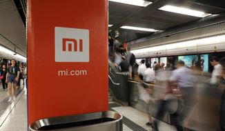 FILE - In this July 9, 2018, file photo, an advertisement for Xiaomi is displayed at a subway station in Hong Kong. The U.S. government has blacklisted Chinese smartphone maker Xiaomi Corp. and China’s third-largest national oil company for alleged military links, heaping pressure on Beijing in President Donald Trump’s last week in office. The Department of Defense added nine companies to its list of Chinese companies with military links, including Xiaomi and state-owned plane manufacturer Commercial Aircraft Corp. of China (Comac). (AP Photo/Vincent Yu, File)