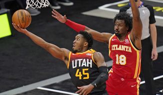 Utah Jazz guard Donovan Mitchell (45) lays the ball up as Atlanta Hawks forward Solomon Hill (18) defends during the first half of an NBA basketball game Friday, Jan. 15, 2021, in Salt Lake City. (AP Photo/Rick Bowmer)