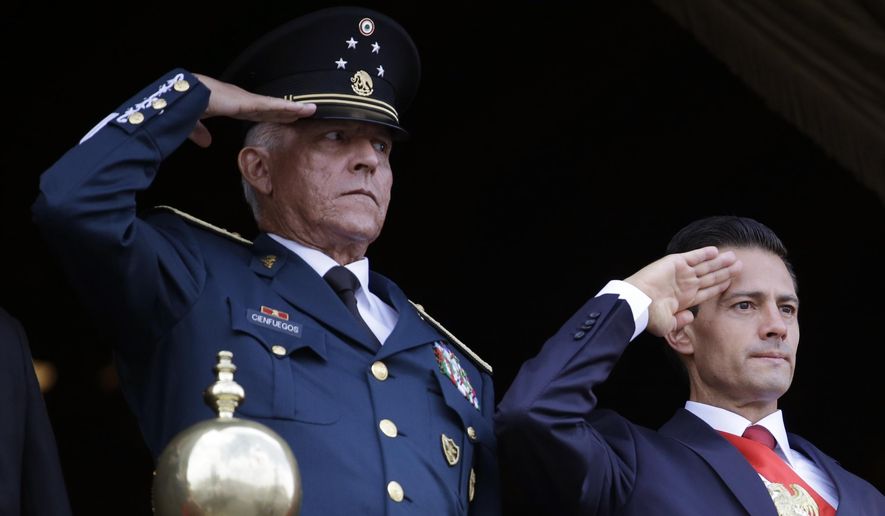 FILE - In this Sept. 16, 2016 file photo, Defense Secretary Gen. Salvador Cienfuegos, left, and Mexico's President Enrique Pena Nieto, salute during the annual Independence Day military parade in Mexico City's main square. The U.S. Justice Department is dropping its drug trafficking and money laundering against former Mexican defense secretary Gen. Salvador Cienfuegos, Attorney General William Barr said Tuesday, Nov. 17, 2020. (AP Photo/Rebecca Blackwell, File)