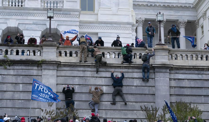 In this Jan. 6, 2021, file photo, supporters of President Donald Trump climb the west wall of the U.S. Capitol in Washington. (AP Photo/Jose Luis Magana, File)
