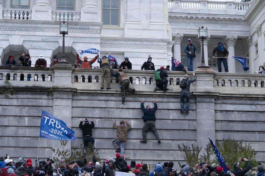 In this Jan. 6, 2021, file photo, supporters of President Donald Trump climb the west wall of the U.S. Capitol in Washington. (AP Photo/Jose Luis Magana, File)
