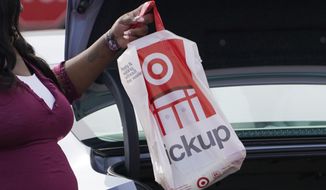 In this Nov. 5, 2020 file photo, a Target employee places a curbside pickup purchase into the trunk of a customer in Jackson, Miss. The nation’s largest retail trade group says Friday, Jan. 15, 2021,  that holiday sales soared 8.3%, far exceeding its forecast even as the coronavirus kept shoppers away from physical stores.  (AP Photo/Rogelio V. Solis, File) **FILE**