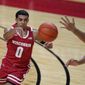 Wisconsin&#39;s D&#39;Mitrik Trice, left, passes the ball past Rutgers&#39; Ron Harper Jr. during the first half of an NCAA college basketball game Friday, Jan. 15, 2021, in Piscataway, N.J. (AP Photo/Seth Wenig)