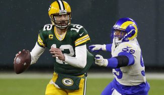 Green Bay Packers quarterback Aaron Rodgers (12) throws under pressure from Los Angeles Rams&#39; Aaron Donald (99) during the first half of an NFL divisional playoff football game Saturday, Jan. 16, 2021, in Green Bay, Wis. (AP Photo/Matt Ludtke)