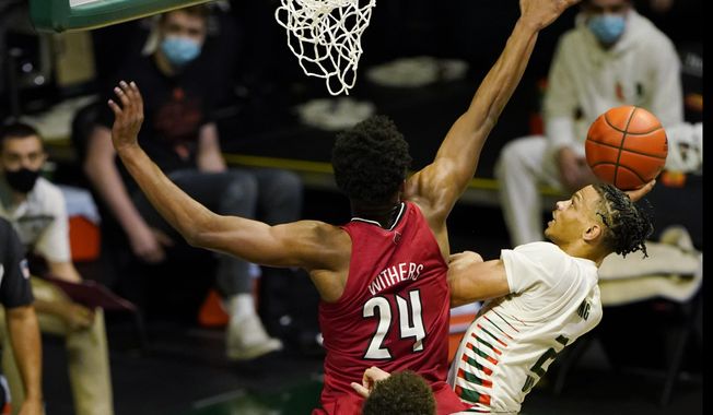 Miami guard Isaiah Wong (2) drives to the basket as Louisville forward Jae&#x27;Lyn Withers (24) defends, during the second half of an NCAA college basketball game, Saturday, Jan. 16, 2021, in Coral Gables, Fla. (AP Photo/Marta Lavandier)