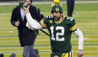 Green Bay Packers quarterback Aaron Rodgers pumps his fist after an NFL divisional playoff football game against the Los Angeles Rams Saturday, Jan. 16, 2021, in Green Bay, Wis. The Packers defeated the Rams 32-18 to advance to the NFC championship game. (AP Photo/Mike Roemer)
