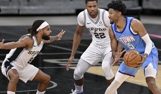 Houston Rockets&#39; Christian Wood, right, looks to pass as he is defended by San Antonio Spurs&#39; Rudy Gay (22) and Patty Mills during the first half of an NBA basketball game, Saturday, Jan. 16, 2021, in San Antonio. (AP Photo/Darren Abate)
