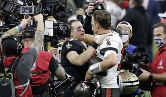 New Orleans Saints quarterback Drew Brees, center left, speaks with Tampa Bay Buccaneers quarterback Tom Brady after an NFL divisional round playoff football game, Sunday, Jan. 17, 2021, in New Orleans. The Buccaneers won 30-20. (AP Photo/Butch Dill)