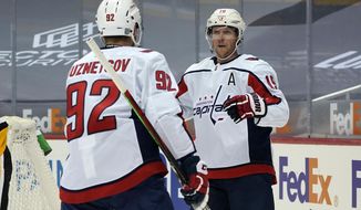 Washington Capitals&#39; Nicklas Backstrom (19) celebrates his goal with Evgeny Kuznetsov during the second period of an NHL hockey game against the Pittsburgh Penguins in Pittsburgh, Sunday, Jan. 17, 2021. (AP Photo/Gene J. Puskar)