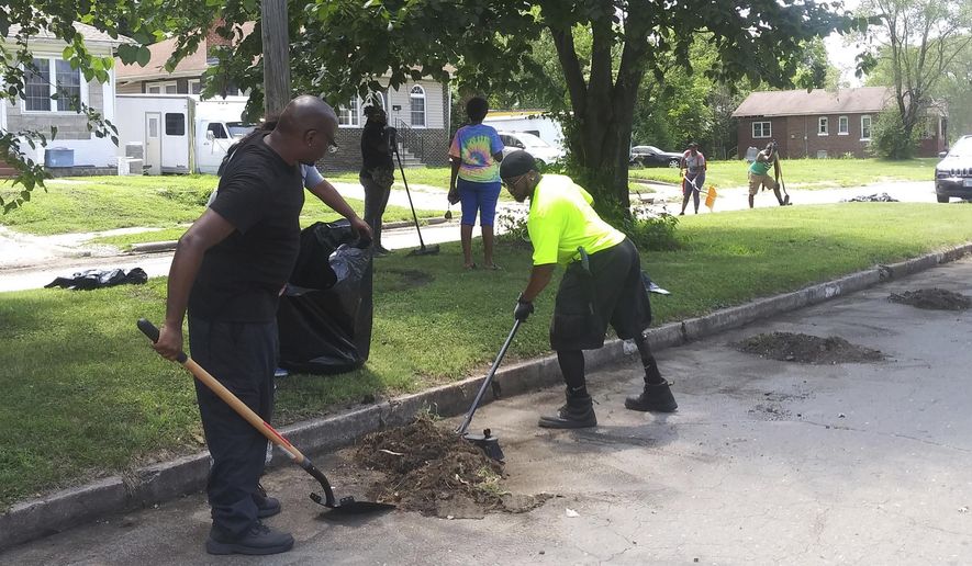 This July 18, 2020 photo shows The R.E.C. team (Regular Everyday Citizens) in East St. Louis, Ill.  The cleanup is part of Empire 13’s Boots to the Streets Campaign, which addresses racial and social issues related to discrimination in Black communities. Empire 13, which J.D. Dixon formed, is a grassroots organization of Black workers from Empire Comfort Systems in Belleville who want to end racism in the workplace and beyond. Dixon is a machine operator at Empire. (DeAsia Page/Belleville News-Democrat via AP)