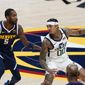 Utah Jazz guard Jordan Clarkson, right, looks to pass the ball as Denver Nuggets forward Will Barton defends in the first half of an NBA basketball game Sunday, Jan. 17, 2021, in Denver. (AP Photo/David Zalubowski)