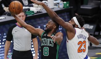 Boston Celtics&#39; Kemba Walker (8) shoots against New York Knicks&#39; Mitchell Robinson (23) during the first half of an NBA basketball game, Sunday, Jan. 17, 2021, in Boston. (AP Photo/Michael Dwyer)