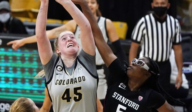 Stanford forward Francesca Belibi, right, blocks a shot by Colorado forward Charlotte Whittaker in the first half of an NCAA college basketball game Sunday, Jan. 17, 2021, in Boulder, Colo. (AP Photo/David Zalubowski)
