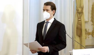Austrian Chancellor Sebastian Kurz with a face mask walks at the federal chancellery in Vienna, Austria, Sunday, Jan. 17, 2021. The Austrian government has moved to restrict freedom of movement for people, in an effort to slow the onset of the COVID-19 coronavirus. (AP Photo/Ronald Zak)