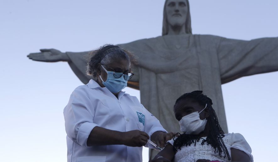 Terezinha da Conceicao, 80, is the first women to receive the COVID-19 vaccine produced by China&#39;s Sinovac Biotech Ltd, during the start of the vaccination program in front of the statue of Cristo Redentor, in the city of Rio de Janeiro, Brazil, Monday, Jan. 18, 2021. (AP Photo/Bruna Prado)