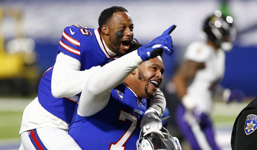 Buffalo Bills&#39; Taiwan Jones (25) celebrates with Dion Dawkins (73) after an NFL divisional round football game against the Baltimore Ravens Saturday, Jan. 16, 2021, in Orchard Park, N.Y. The Bills won 17-3. (AP Photo/John Munson)
