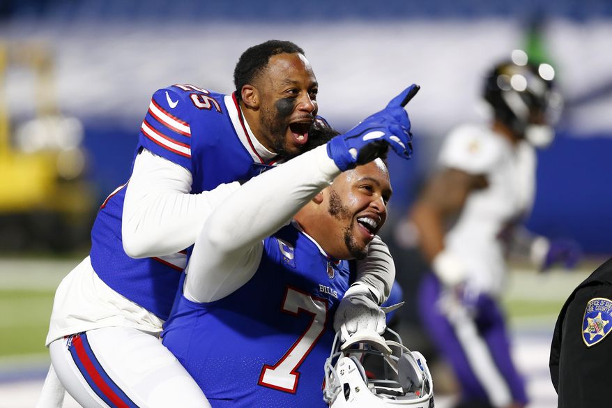 Buffalo Bills&#x27; Taiwan Jones (25) celebrates with Dion Dawkins (73) after an NFL divisional round football game against the Baltimore Ravens Saturday, Jan. 16, 2021, in Orchard Park, N.Y. The Bills won 17-3. (AP Photo/John Munson)