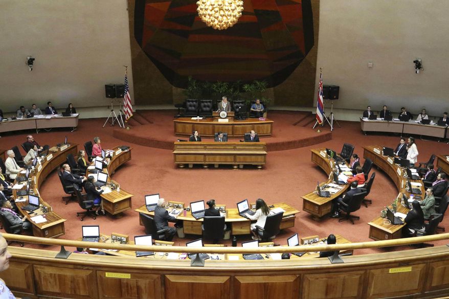 FILE -- This May 2, 2019 file photo shows lawmakers meet on the floor of the state House of Representatives at the Hawaii State Capitol in Honolulu. Cut spending, raise taxes, or perhaps both. Hawaii lawmakers face tough choices as they convene a new legislative session this week amid a pandemic that has pummeled tourism, the state's biggest industry, and depleted tax revenue. Lawmakers expect to spend time addressing how to spend federal funds allocated to help Hawaii test for the coronavirus, distribute vaccines, and bolster hospitals. They'll also consider how to help Hawaii's economy recover from the public health crisis. (AP Photo/Audrey McAvoy, File)