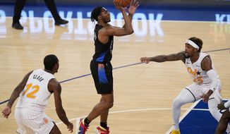 New York Knicks guard Immanuel Quickley (5) goes up for a shot with Orlando Magic forward Gary Clark (12) and Magic guard Jordan Bone (23) reacting during the first half of an NBA basketball game, Monday, Jan. 18, 2021, in New York. (AP Photo/Kathy Willens, Pool)