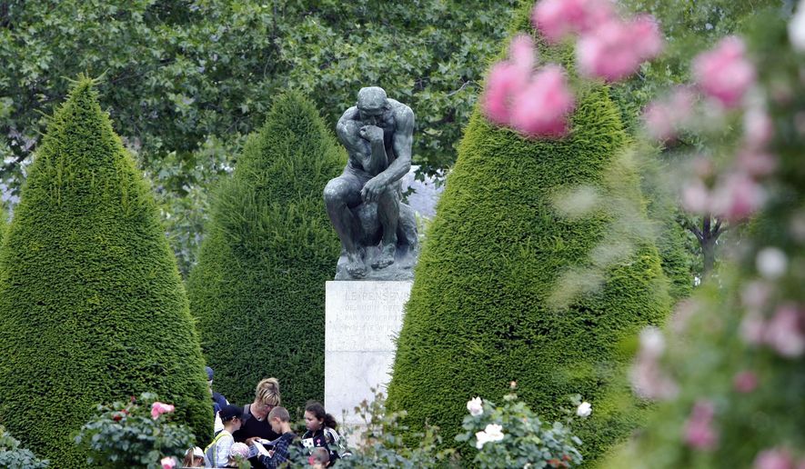 FILE - In this Tuesday, May 31, 2011 file photo, people stand in the garden of the Rodin museum in Paris. There is a ray of light for Parisians who, like the rest of the French nation this weekend, begin to observe a tightened coronavirus curfew. The famous Rodin Museum sculpture garden reopened to visitors on Saturday, Jan. 16, 2021. Though the rococo museum, showcasing the world’s largest collection of Rodin sculptures, remains closed, visitors are now able to enter the sculpture-filled surrounding gardens that overlooked the gold dome of Les Invalides monument. (AP Photo/Remy de la Mauviniere, File)
