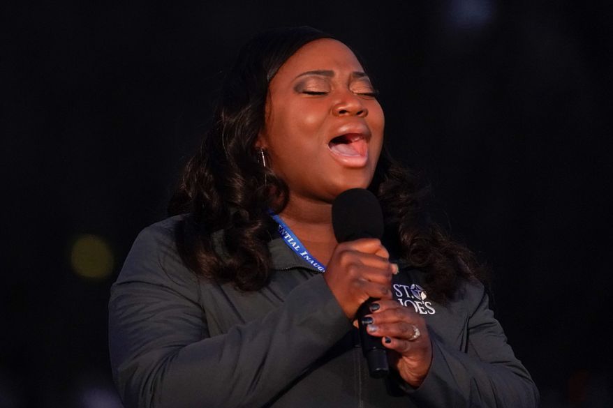 Nurse Lori Marie Key sings "Amazing Grace" during a COVID-19 memorial ceremony on Tuesday in Washington. (Associated Press photographs)