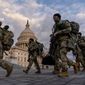 Armed National Guard troops walk past the U.S. Capitol two days before the 59th Presidential Inauguration in Washington, Monday, Jan. 18, 2021. (AP Photo/Andrew Harnik)