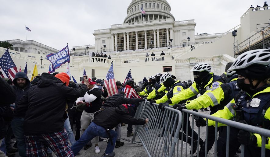 In this Wednesday, Jan. 6, 2021, file photo, Trump supporters try to break through a police barrier at the Capitol in Washington. (AP Photo/Julio Cortez)