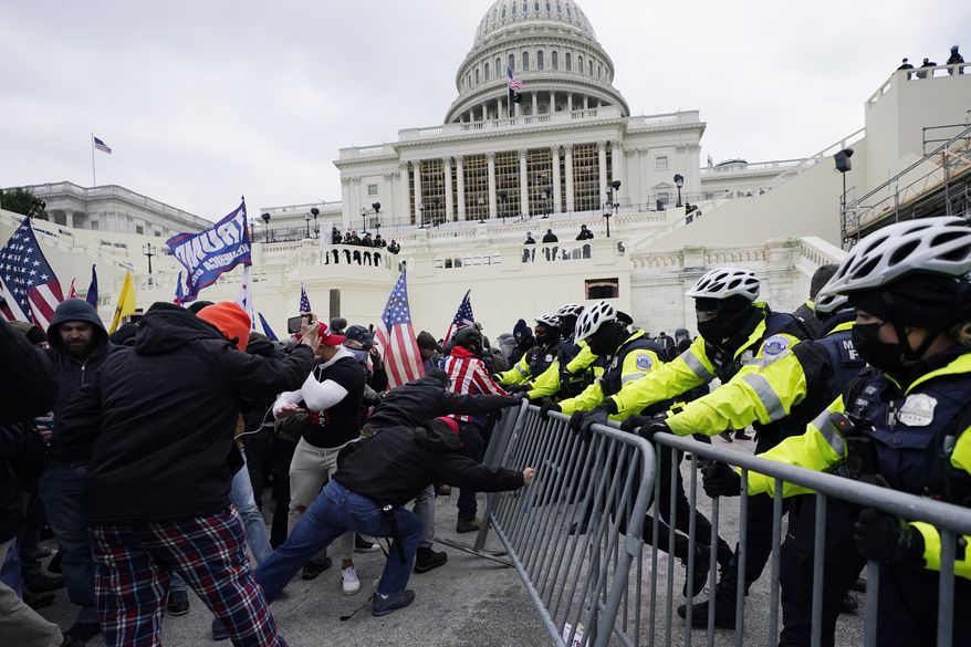 In this Wednesday, Jan. 6, 2021, file photo, Trump supporters try to break through a police barrier at the Capitol in Washington. (AP Photo/Julio Cortez)
