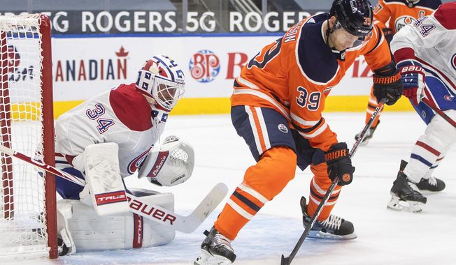 Edmonton Oilers&#x27; Alex Chiasson (39) tries to tip the puck in past Montreal Canadiens goalie Jake Allen (34) during second-period NHL hockey game action in Edmonton, Alberta, Monday, Jan. 18, 2021. (Jason Franson/The Canadian Press via AP)