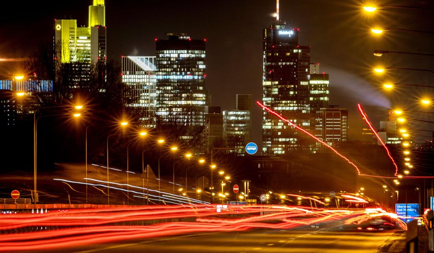 Long time exposure photo shows commuters driving towards Frankfurt, Germany, Thursday, Jan. 14, 2021. In background the buildings of the banking district. (AP Photo/Michael Probst)