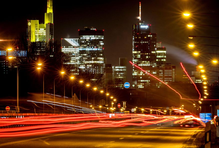 Long time exposure photo shows commuters driving towards Frankfurt, Germany, Thursday, Jan. 14, 2021. In background the buildings of the banking district. (AP Photo/Michael Probst)