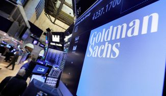 FILE - In this Dec. 13, 2016, file photo, the logo for Goldman Sachs appears above a trading post on the floor of the New York Stock Exchange. Goldman Sachs said its profits more than doubled from a year earlier thanks to a surge in both trading and advising revenue. (AP Photo/Richard Drew, File)