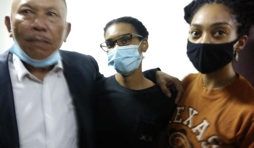 American graphic designer Kristen Antoinette Gray, center, her partner Saundra Michelle Alexander, right, and lawyer Erwin Siregar arrive at the local immigration office for questioning, in Denpasar, Bali, Indonesia, Tuesday, Jan. 19, 2021. Gray, who arrived in Bali in January 2020 and wound up staying through the coronavirus pandemic, is being deported from the Indonesian resort island over her viral tweets that celebrated it as a low-cost, queer-friendly place for foreigners to live. (AP Photo)