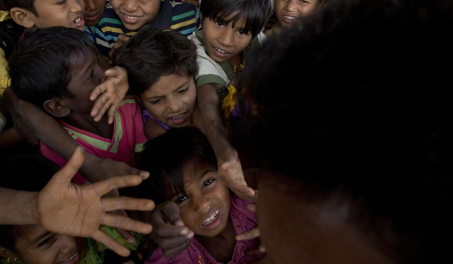 In this Wednesday, Jan. 17, 2018, file photo, Rohingya refugee children push each other to receive a packet of Khichdi, made from rice and lentils, at a food distribution centre in Balukhali refugee camp near Cox's Bazar, Bangladesh. United Nations agencies are warning that more than 350 million people in the Asia-Pacific are going hungry as the coronavirus pandemic destroys jobs and pushes food prices higher. (AP Photo/Manish Swarup, File)