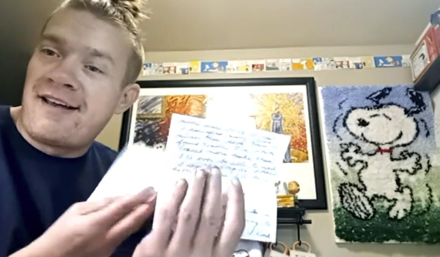 In this Dec. 20, 2020, still image taken from video, Wesley Morgan, a 32-year-old in Denver, shows a letter from one of his “Peanuts” pen pals. After being furloughed from his job at the Denver International Airport, Morgan began writing to over 500 older adults living in isolation due to the pandemic. He says 142 responded, and many have become consistent correspondents. (AP Photo/Jessie Wardarski)