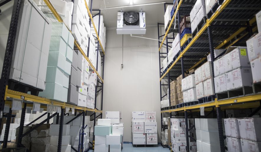 Boxes of vaccines, unrelated to COVID-19, are stored in a large refrigerator, during a media tour of the ministry warehouse where the vaccine for the new coronavirus will also be stored in freezers in Bogota, Colombia, Tuesday, Jan. 19, 2021. (AP Photo/Ivan Valencia)