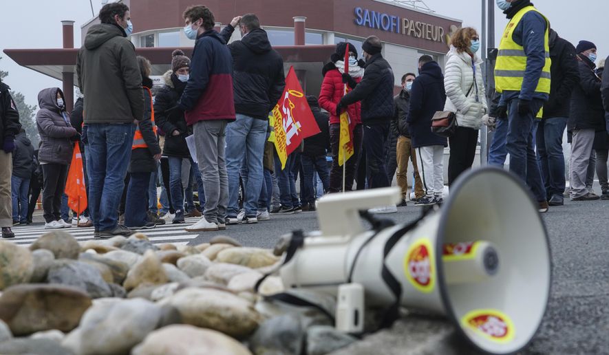 Striking workers gather outside the French pharmaceutical company Sanofi headquarters in Marcy l&#39;Etoile, central France, Tuesday, Jan.19, 2021. Employees of pharmaceutical company Sanofi stage a protest against planned redundancies that they say could slow the fight against the Coronavirus pandemic . Sanofi had been developing Covid vaccines but will not be ready to roll out until late 2021. (AP Photo/Laurent Cipriani)