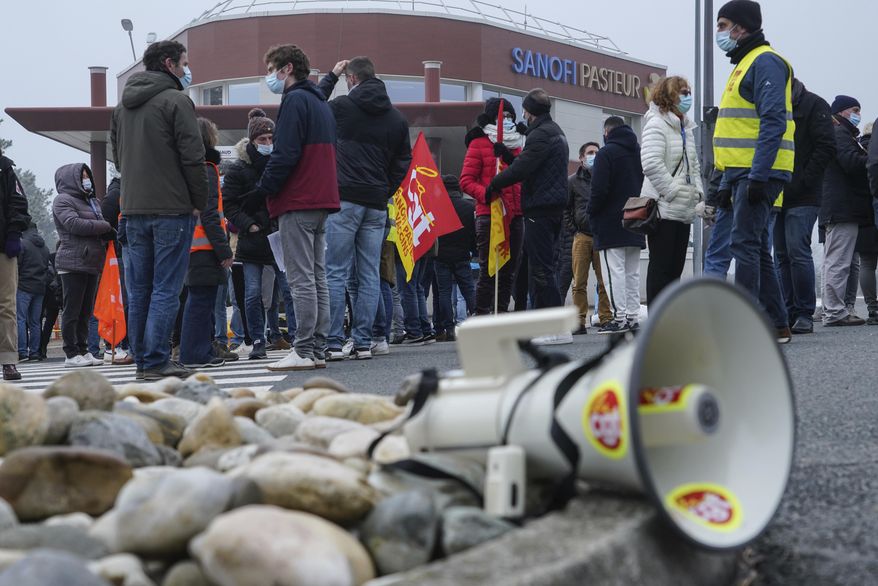 Striking workers gather outside the French pharmaceutical company Sanofi headquarters in Marcy l&#39;Etoile, central France, Tuesday, Jan.19, 2021. Employees of pharmaceutical company Sanofi stage a protest against planned redundancies that they say could slow the fight against the Coronavirus pandemic . Sanofi had been developing Covid vaccines but will not be ready to roll out until late 2021. (AP Photo/Laurent Cipriani)