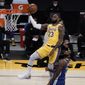 Los Angeles Lakers&#39; LeBron James, top, goes up for a basket as Golden State Warriors&#39; Andrew Wiggins watches during the first half of an NBA basketball game, Monday, Jan. 18, 2021, in Los Angeles. (AP Photo/Jae C. Hong)